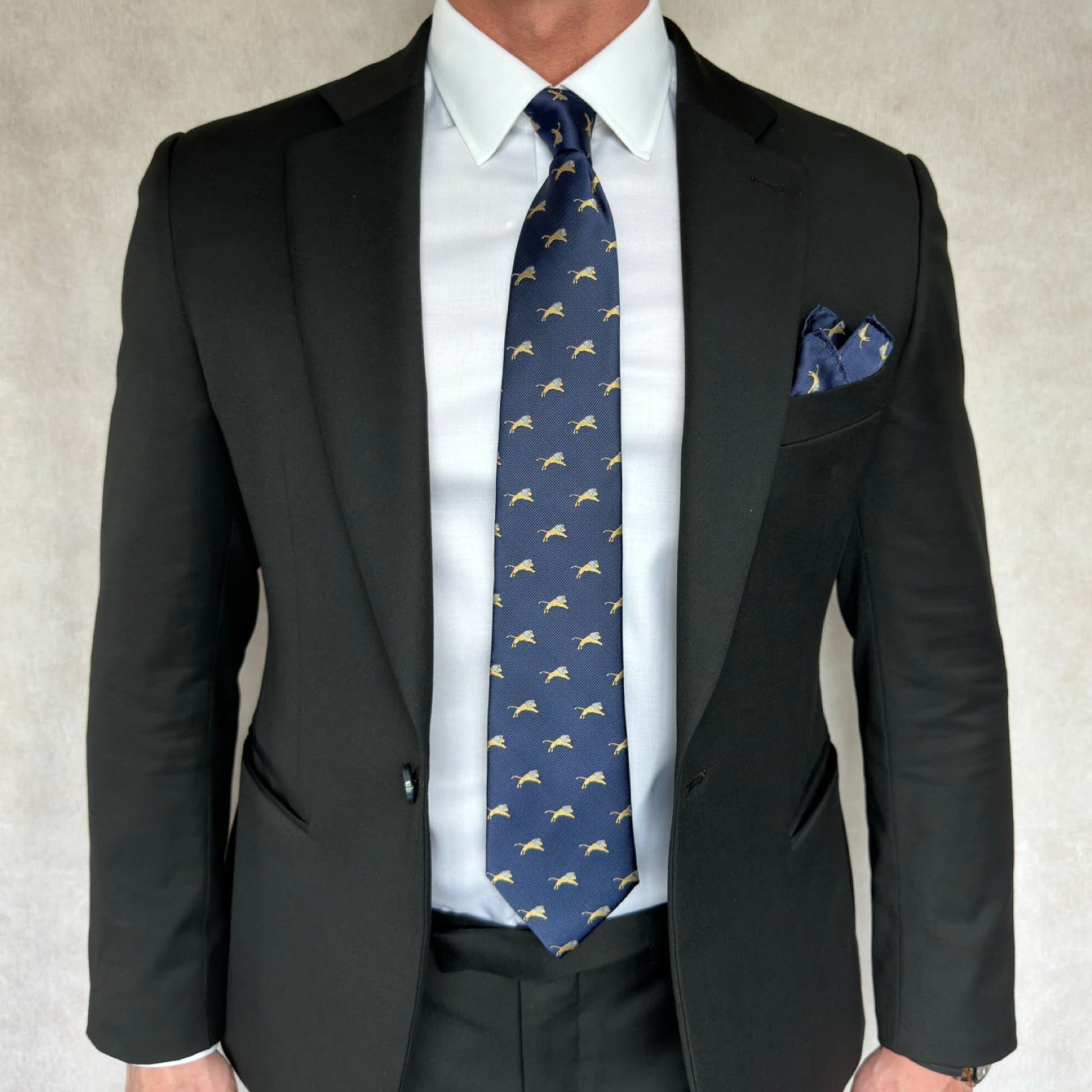 gentleman showcasing a bold blue necktie with gold and silver lion pattern throughout
