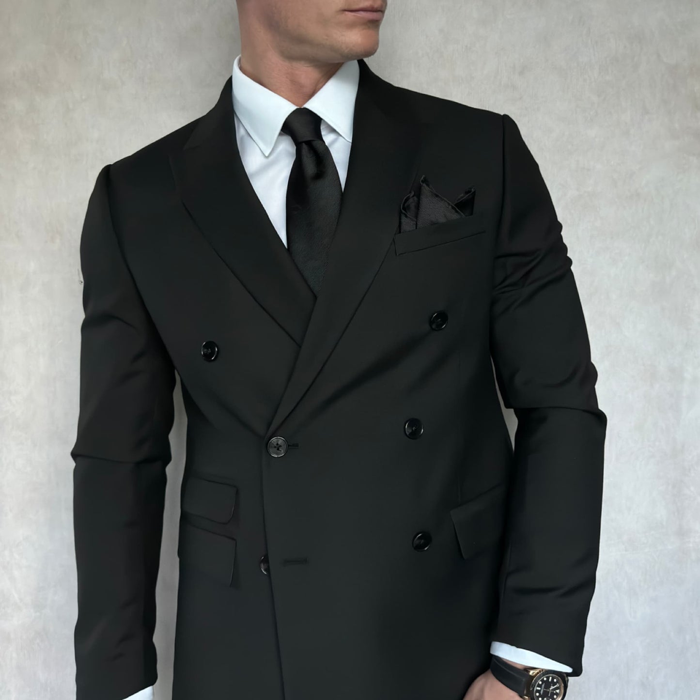 gentleman wearing a black double breasted blazer, white shirt and black tie with a black rhino silhouette pattern 